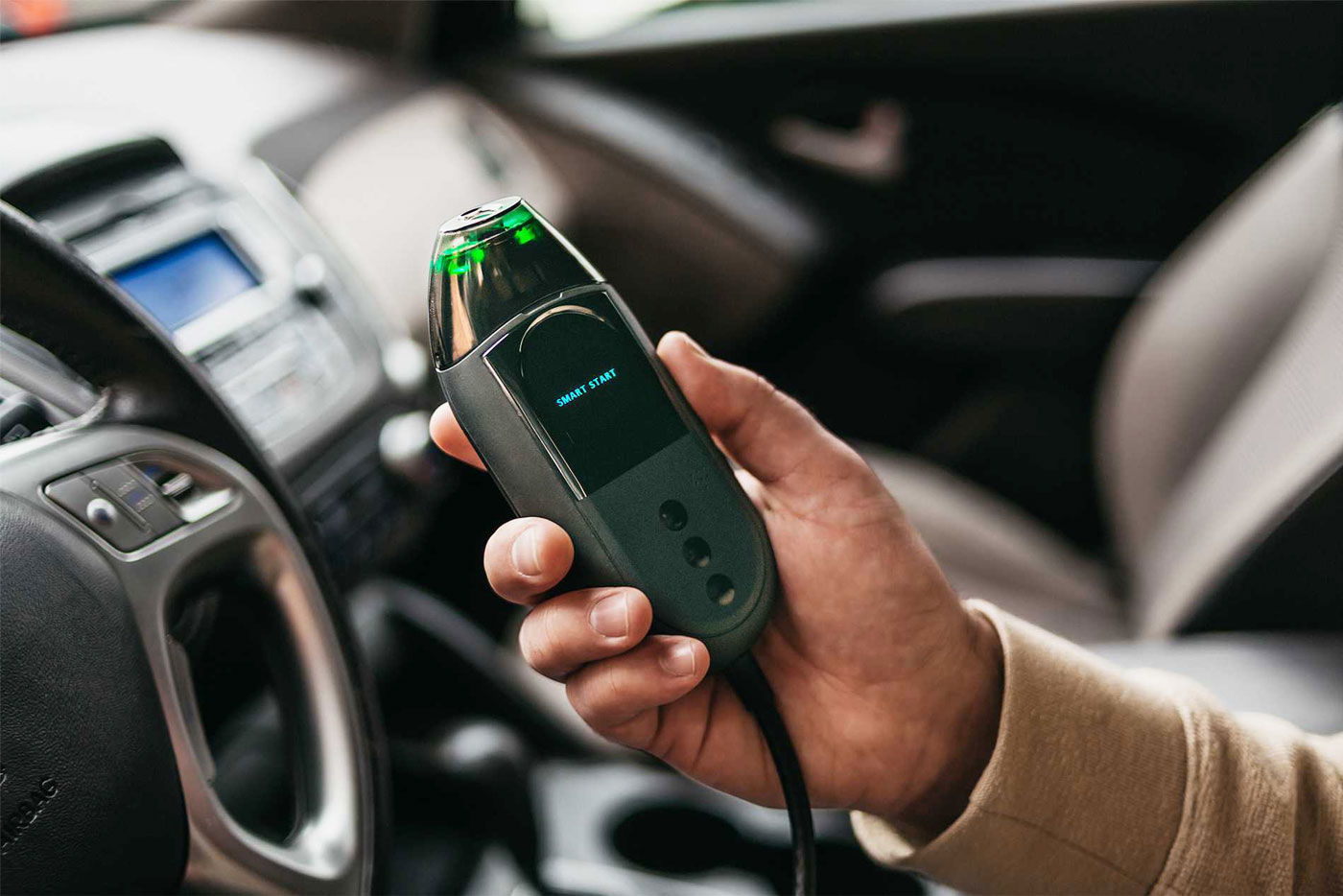 ssmi_web_images_IIFlex person holding an ignition interlock device unit in a vehicle